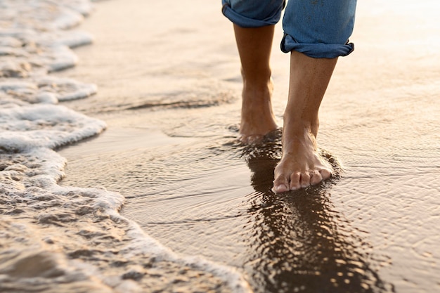 Foto donna che fa una passeggiata sulla sabbia della spiaggia