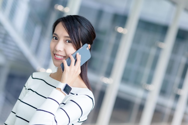 女性が携帯電話に話しかける