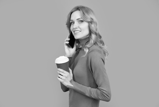 Женщина разговаривает по телефону, держа чашку Мобильная связь Мобильный кофе или эспрессо в любое время в любом месте