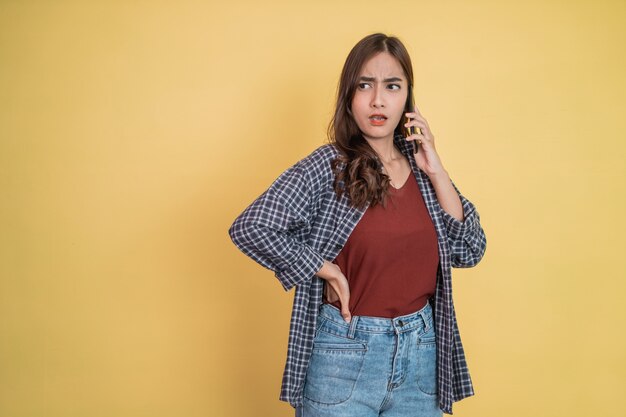 Una donna che parla su una chiamata utilizzando un telefono cellulare con un'espressione arrabbiata