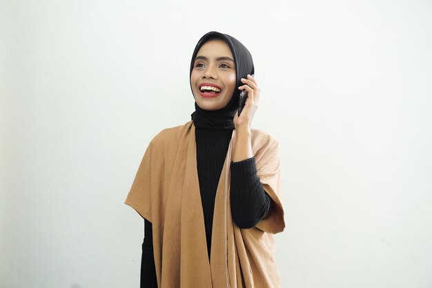 A woman talking on a cell phone and smiling.