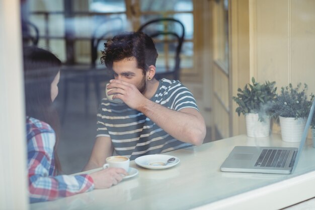 カフェテリアで男と話している女性