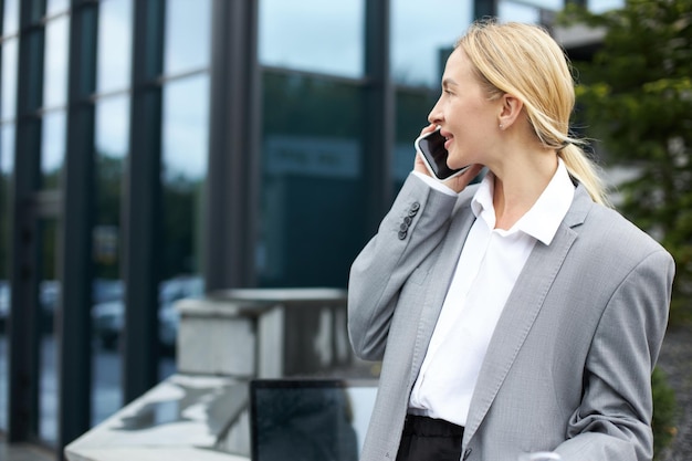 Woman talking on mobile phone walking on the street looking away selective focus Technology concept