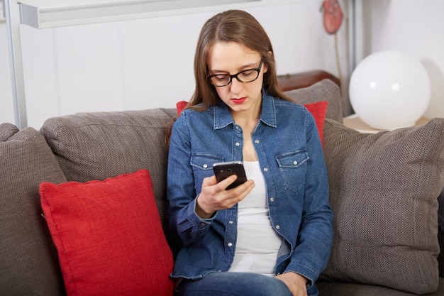 ソファの上の携帯電話に話している女性