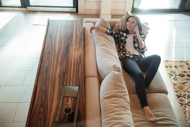 woman talking on phone on couch