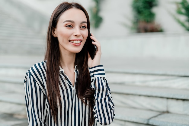 Woman talking on the phone outdoors in the city