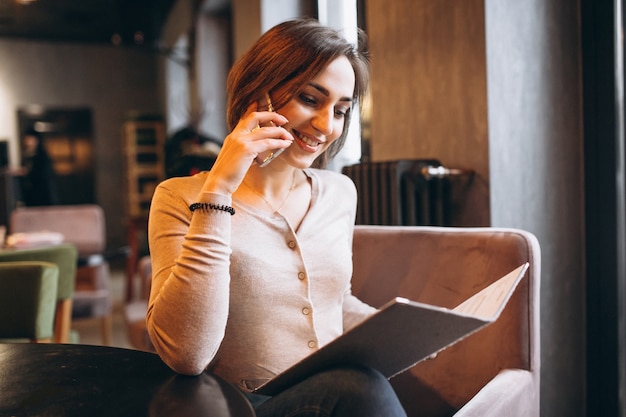 Woman talking on the phone and picking up the menu