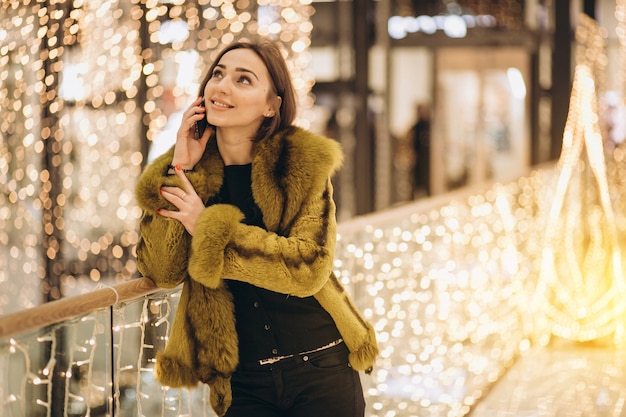 Donna che parla su un telefono in un centro commerciale