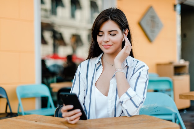 Photo woman talking on the phone through wireless earpods