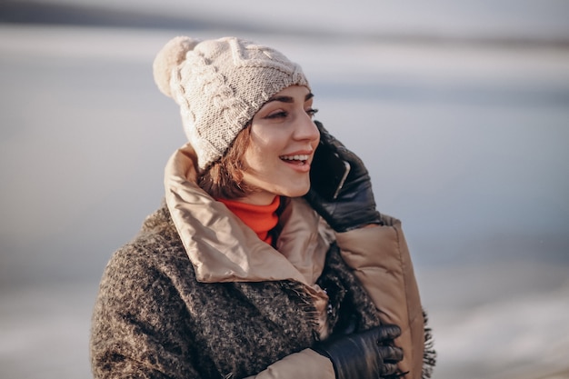 Woman talking on the phone in winter by the lake