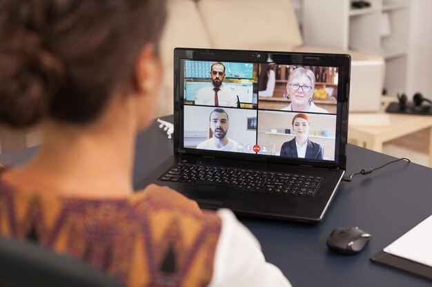 Photo woman talking with work colleagues on video call using tablet computer from home