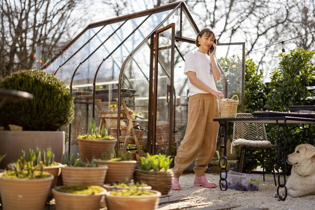 woman talks on phone in garden or flower shop