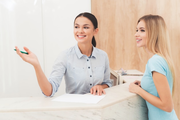 Woman talks with the client and shows something.