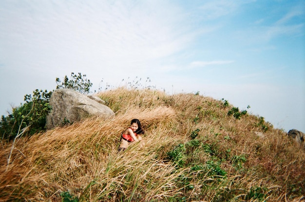 Woman in tall grass against sky