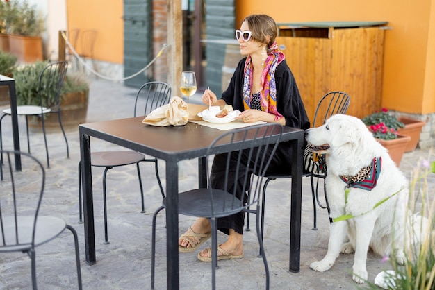 イタリアの地元の農家の店でチーズとワインを味わう女性