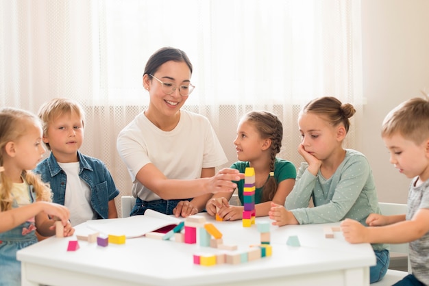 Woman teaching kids how to play with colorful game during class