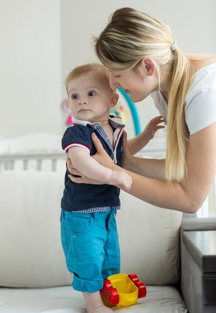 Фото Женщина учит гулять с 1-летним сыном на кровати