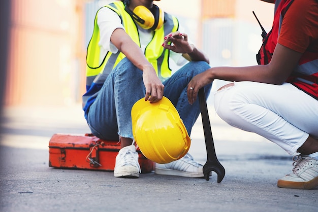 Woman Technician or maintenance worker and sitting down on mechanic tool boxnear and holding wrench