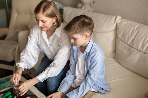 Woman and a teenager are sitting playing a board game.