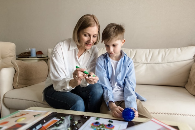 Woman and a teenager are sitting  playing a board game