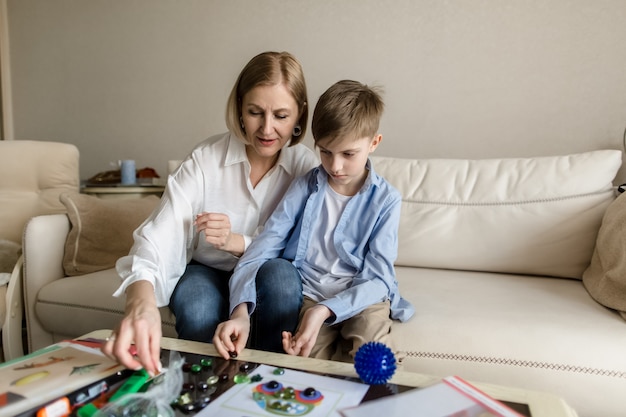 Woman and a teenager are sitting playing a board game.