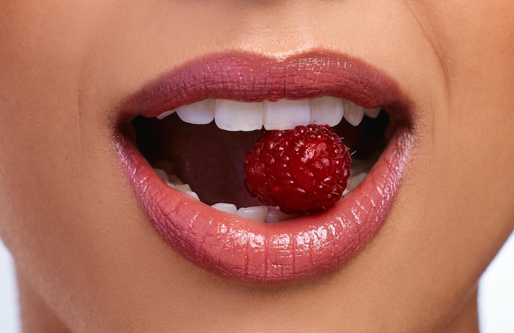 Photo woman teeth and mouth with lipstick and raspberry for dental care hygiene and oral health model girl cosmetics and fruit for smile in studio with glow wellness and vegan for diet or results