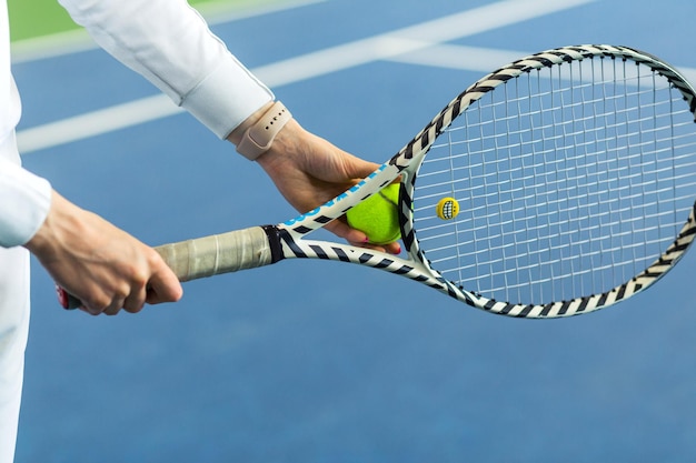 Giocatore di tennis della donna che tiene palla e racchetta nelle sue mani foto orizzontale