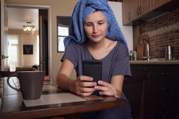 집에서 휴대전화로 문자 메시지를 보내는 여성