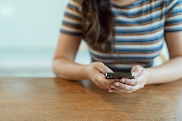 Женщина пишет смс, проверяя социальные сети, держа смартфон дома Разговор с парнем или другом