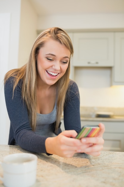 Woman texting in the kitchen