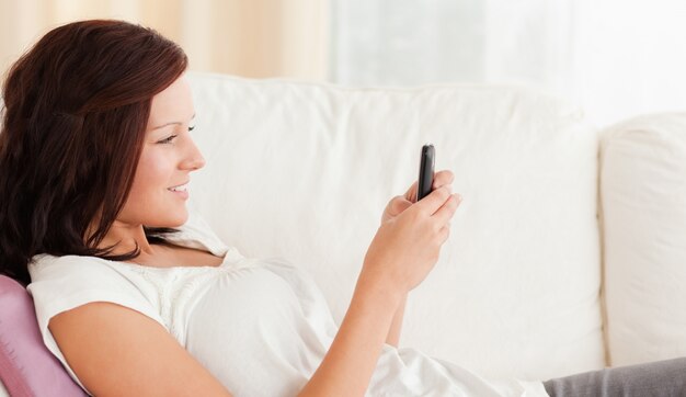 Woman texting while sitting on the sofa