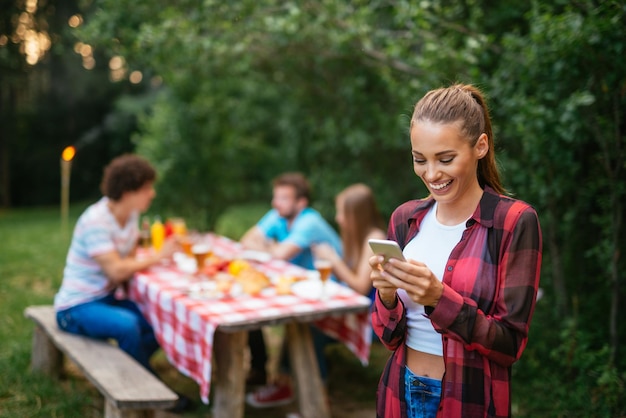 Woman texting with friends on a picnic