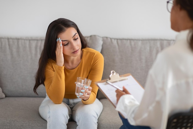 woman in a therapy session holding glass of water