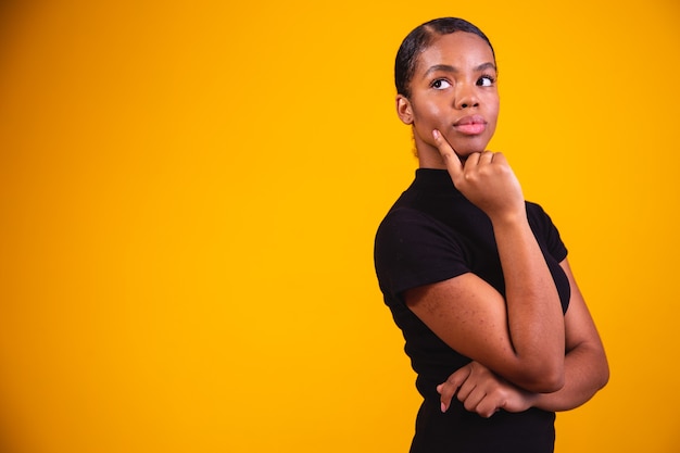 Woman thinking on yellow background. confused and thoughtful woman