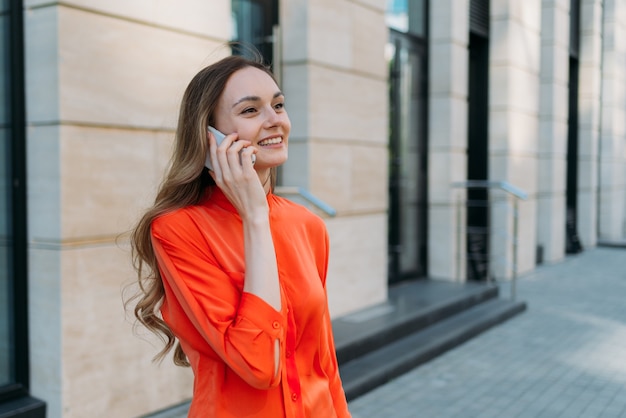 Woman thirties years old communicates on a mobile phone in the city.