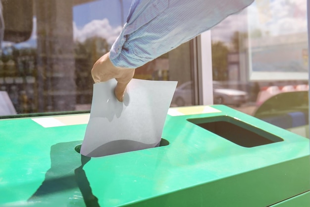 Woman throwing paper into litter bin outdoors