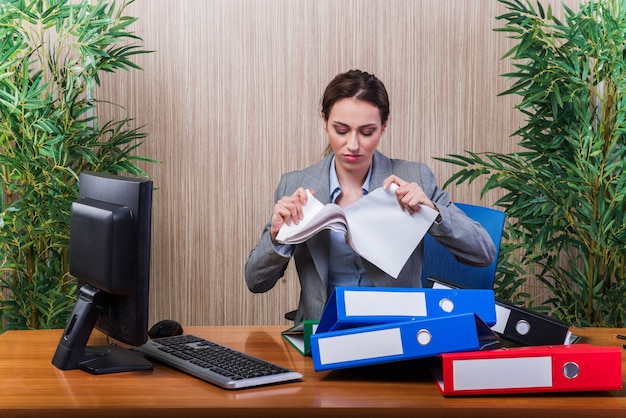 Woman throwing papers in the office under stress