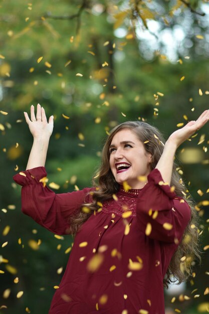 Foto una donna lancia foglie in aria