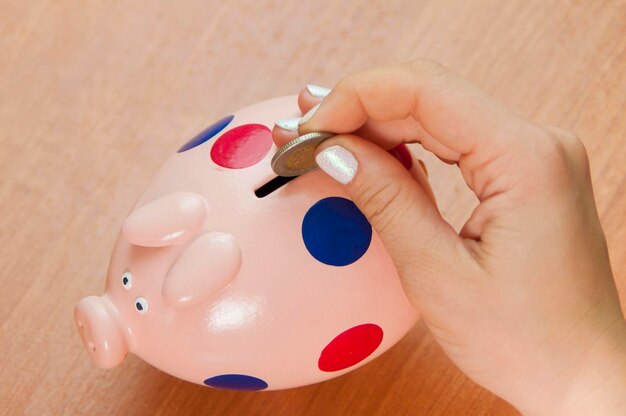 a woman throws money into a piggy bank,