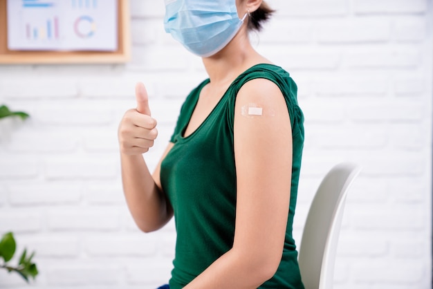 Una donna alza il pollice dopo essersi vaccinata