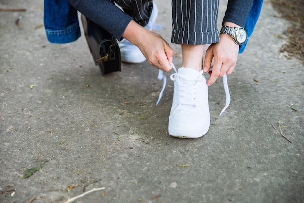 Lacci delle scarpe da donna su scarpe da ginnastica bianche