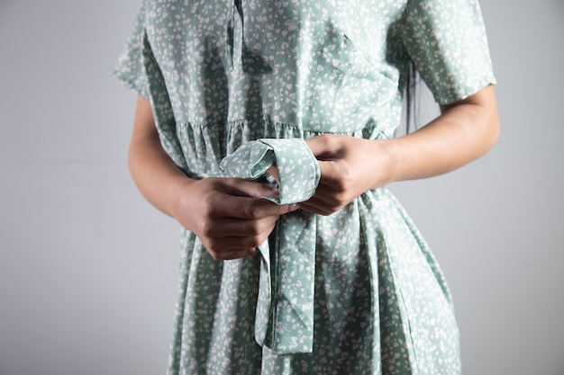 Woman ties a knot at the waist of her dress