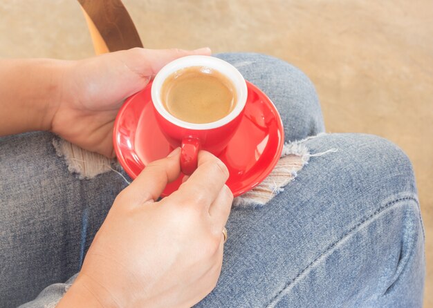 Woman in torn jeans sitting at coffee shop