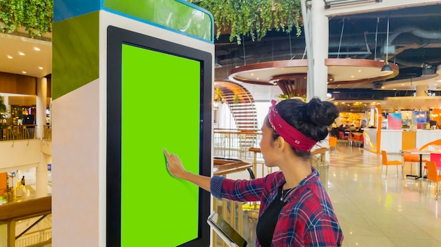 Woman touches a screen of selfordering kiosk