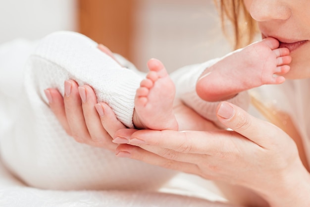 Woman touching feet of newborn baby with hands