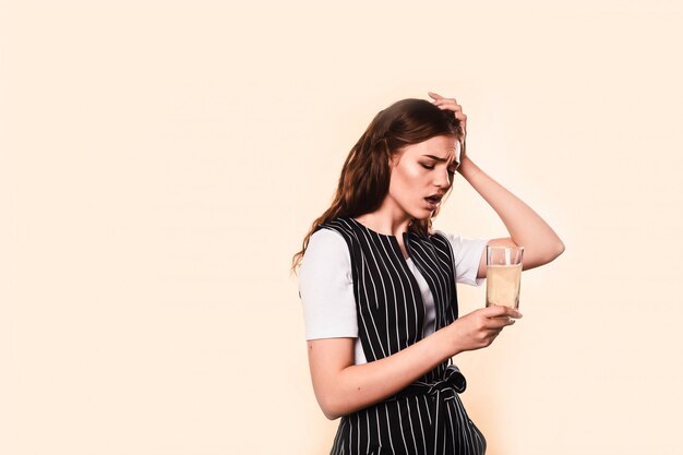 Woman touching her head. Concept of headache and high temperature.Girl takes medicine for headache, soluble tablet in a glass cup