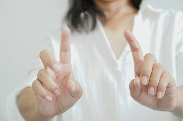 彼女の指で架空の画面に触れる女性。