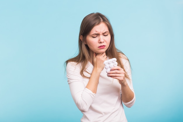 Woman touching the neck on blue wall