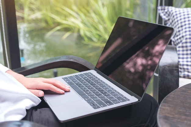 Woman touching and typing on laptop