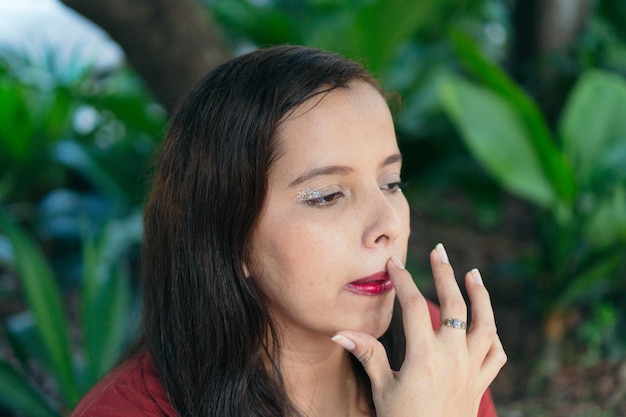 Woman touching up her makeup while in a park